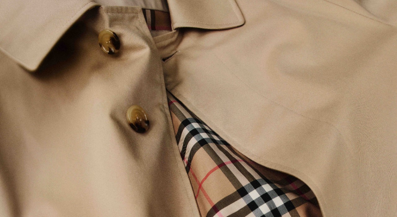 Close-up of a classic Burberry trench coat revealing its heritage check lining — a timeless symbol of British craftsmanship and design.