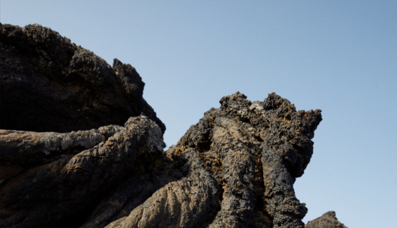 Close-up of rugged rock formations against a clear blue sky.