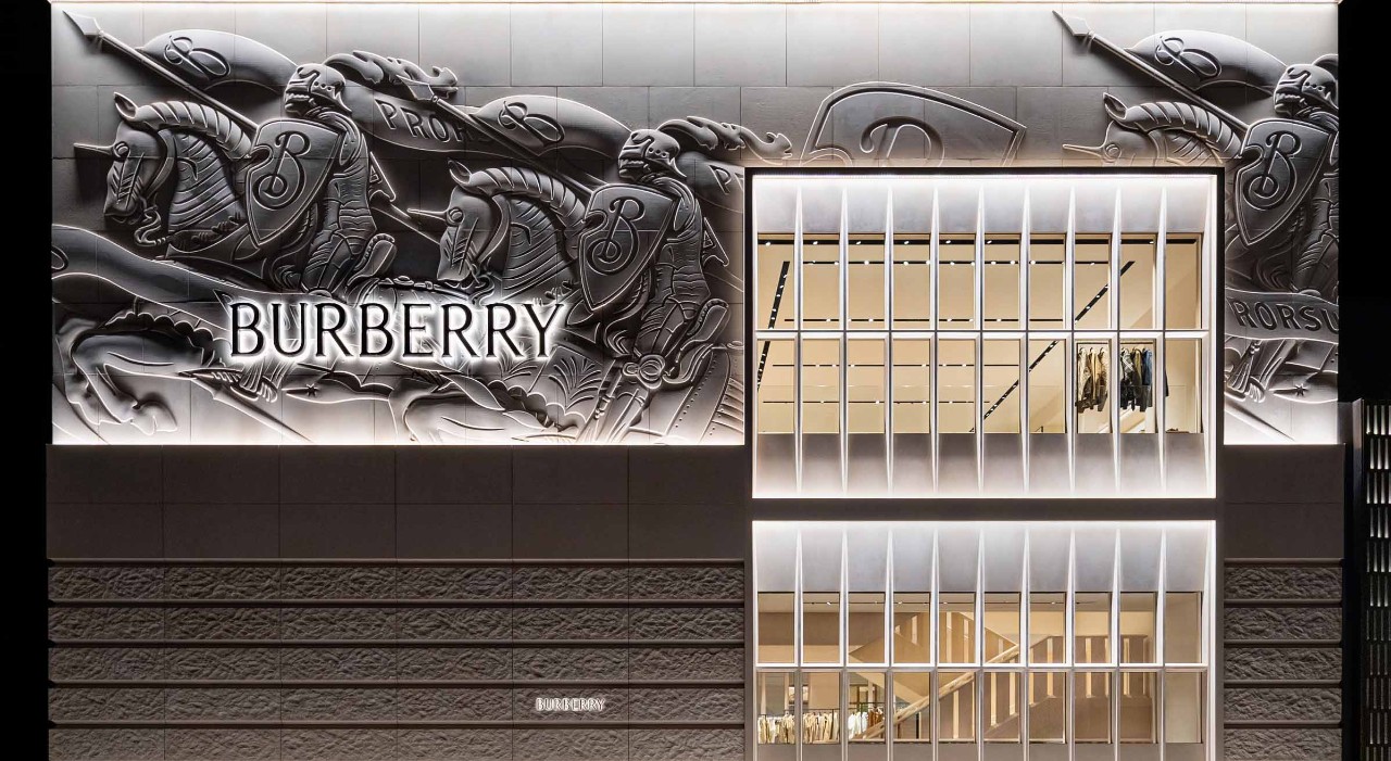 Modern Burberry store exterior featuring illuminated architectural details and sculpted equestrian artwork, representing the brand’s heritage and global presence.