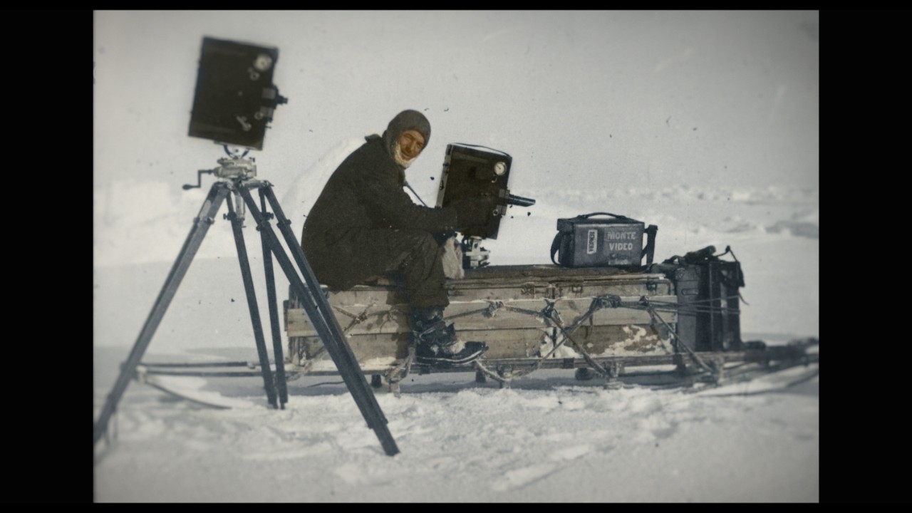 Frank Hurley with his cameras, one of which was a moving image camera: a Prestwich No. 5 cinema camera. (credit: SPRI/Frank Hurley)